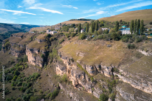 Picturesque panoramic aerial view of a winding rocky gorge with a village on top. Aerial photography. photo