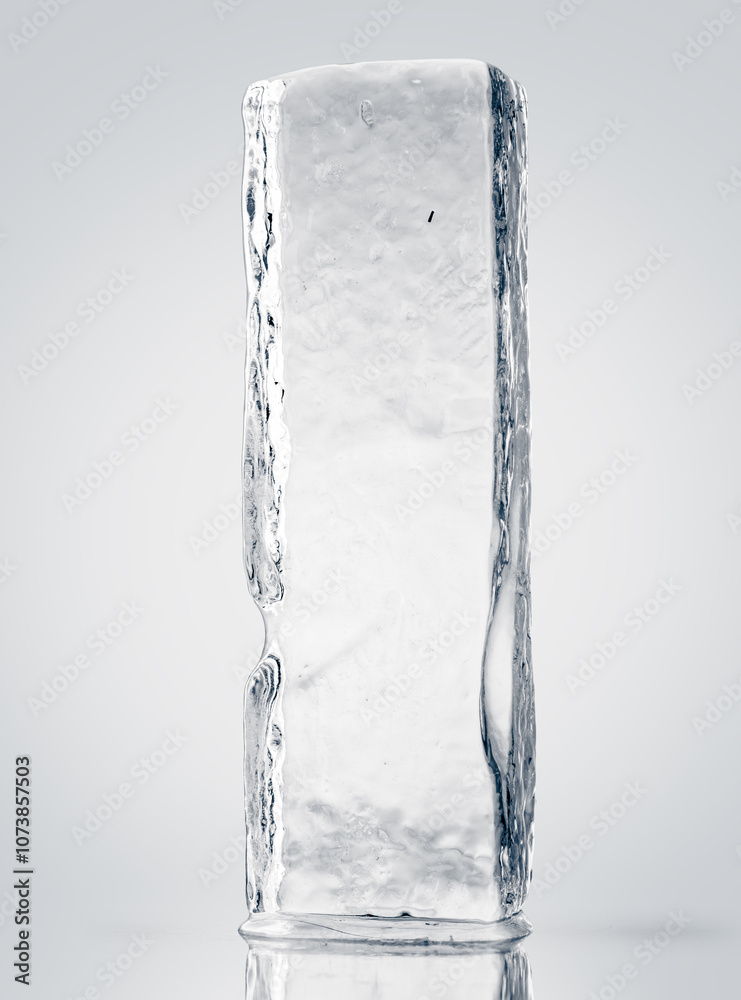 Crystal clear, pure ice block, on white surface with reflection. Rectangular piece of ice. Crystal clear, pure ice block, on white surface with reflection. Rectangular piece of ice.