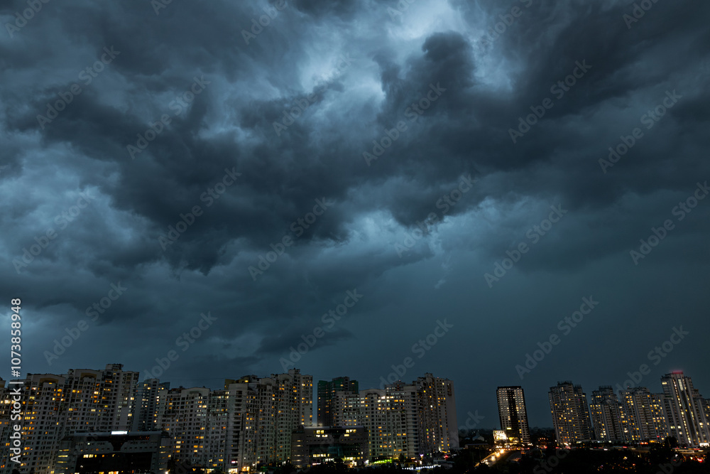 A Dark stormy sky over the dusk residential district of Kyiv city. Ukraine. An illuminated city street in the evening before the coming heavy rain. A Dark stormy sky over the dusk residential district of Kyiv city. Ukraine. An illuminated city street in the evening before the coming heavy rain.