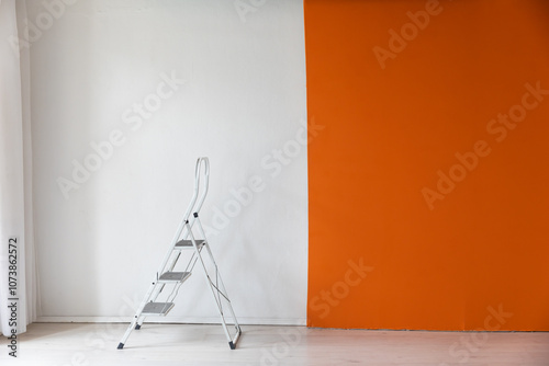 Construction stepladder staircase in the interior of an orange-white room photo