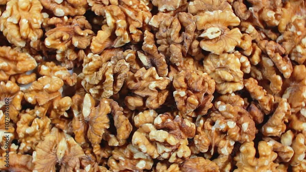 Scattered Shelled Walnuts - Top View, Rotating. Turning Walnut Background. Natural High-Calorie Snacks - Rotation Scattered Shelled Walnuts - Top View, Rotating. Turning Walnut Background. Natural High-Calorie Snacks - Rotation