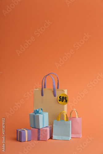 Paper crafts shopping bags shirts and gifts on color background, discount shopping and shopping concept. Black Friday