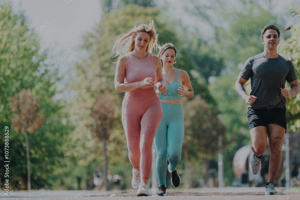 A group of enthusiastic friends jogging in the park on a bright, sunny day, enjoying fitness and outdoor exercise together amidst nature. A group of enthusiastic friends jogging in the park on a bright, sunny day, enjoying fitness and outdoor exercise together amidst nature.