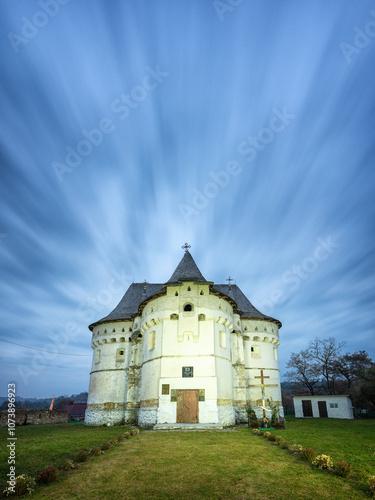 portrait view to old church in blue hour under moving clouds in long exposure with copy space
