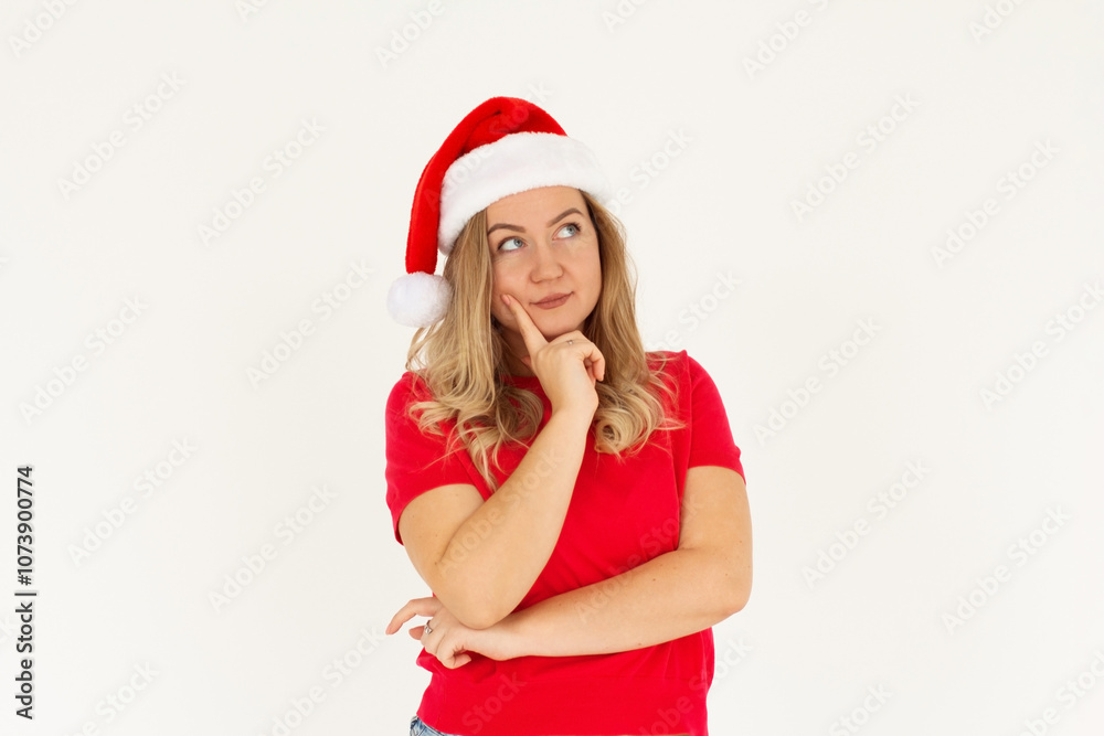 Pensive young brunette Santa woman in t-shirt Christmas hat put hand prop up on chin looking up isolated on white colour background studio portrait. Happy New Year celebration merry holiday concept Pensive young brunette Santa woman in t-shirt Christmas hat put hand prop up on chin looking up isolated on white colour background studio portrait. Happy New Year celebration merry holiday concept