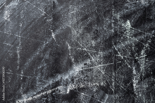 A close-up of a black surface with white scratches