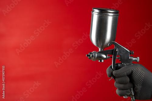 Quadro su tela Painter hand in glove holding an Industrial size airless spray gun used for industrial painting and coating