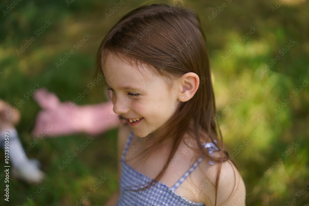 Cute girl in a sundress on the lawn close-up. Concept of children's health, travel, fun Cute girl in a sundress on the lawn close-up. Concept of children's health, travel, fun