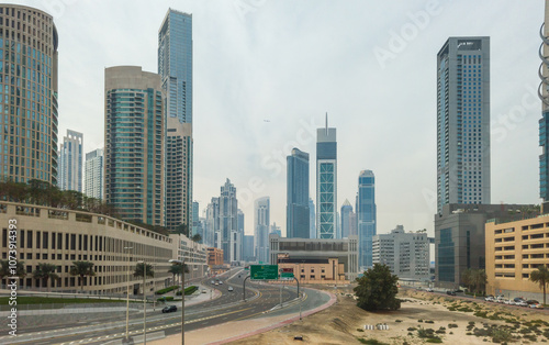 Modern skyscrapers in Downtown Dubai with a wide urban road, creating a captivating cityscape.