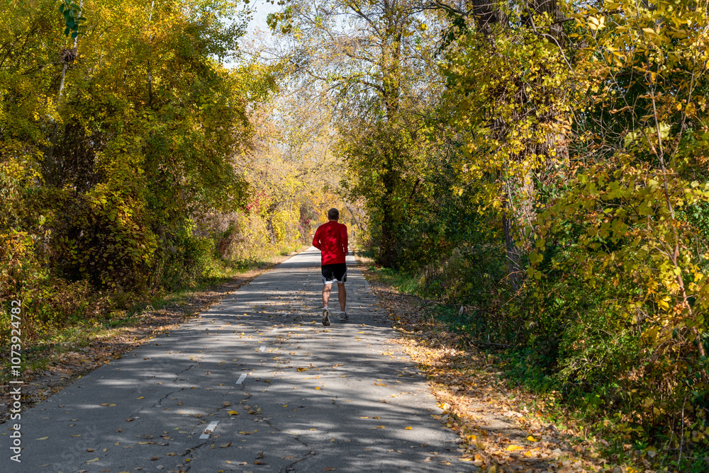 Fototapeta premium Jogger Running On The Fox River Trail In Fall Near De Pere, Wisconsin