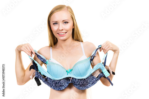 Woman holds bras, choosing photo