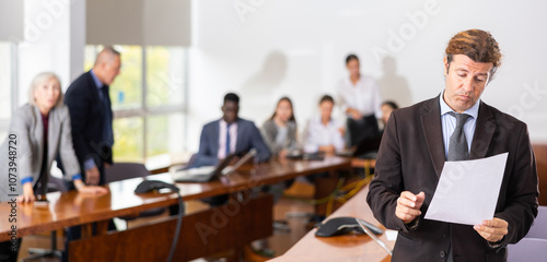 Depressed mid aged white male employee feeling guilty and frustrated while being scolded by furious female boss for bad work result and declining project rates in financial report during corporate photo