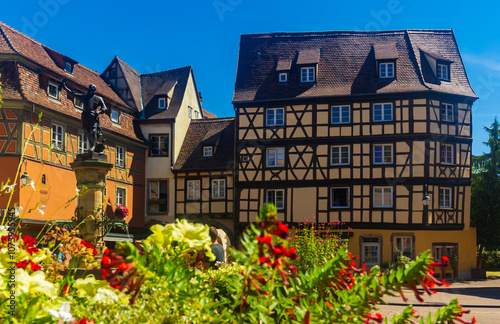 Picturesque summer cityscape of Colmar overlooking cobbled streets with typical residential townhouses on sunny day, France..