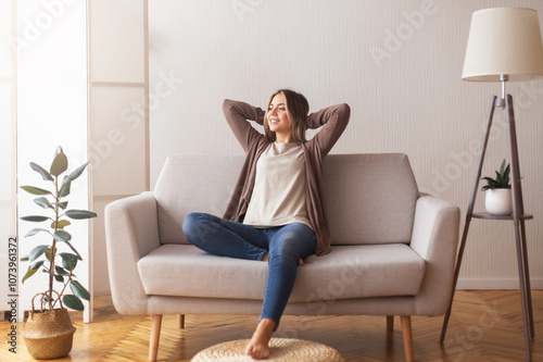 Millennial girl relaxing at home on couch, enjoying weekends, empty space