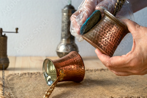 Cleaning and polishing an old cezve with steel wool. Cleaning and polishing copper utensils photo