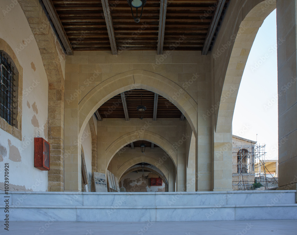 Exploring the beautiful arches of an ancient stone corridor in a historic European city at dusk. Exploring the beautiful arches of an ancient stone corridor in a historic European city at dusk.
