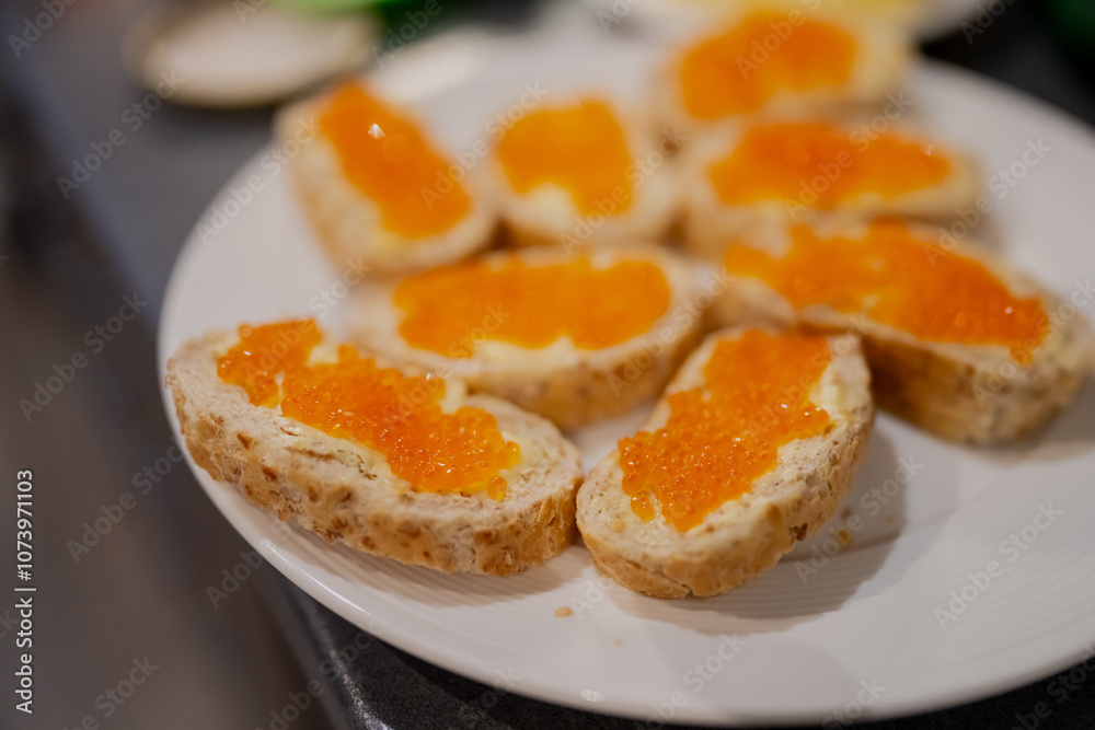 Orange caviar on white bread with butter. Slavic and Baltic typical cuisine for breakfast in the weekend Orange caviar on white bread with butter. Slavic and Baltic typical cuisine for breakfast in the weekend