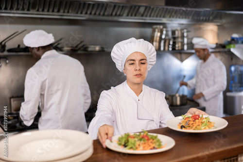 Female chef puts ready meals on shelves in restaurant photo