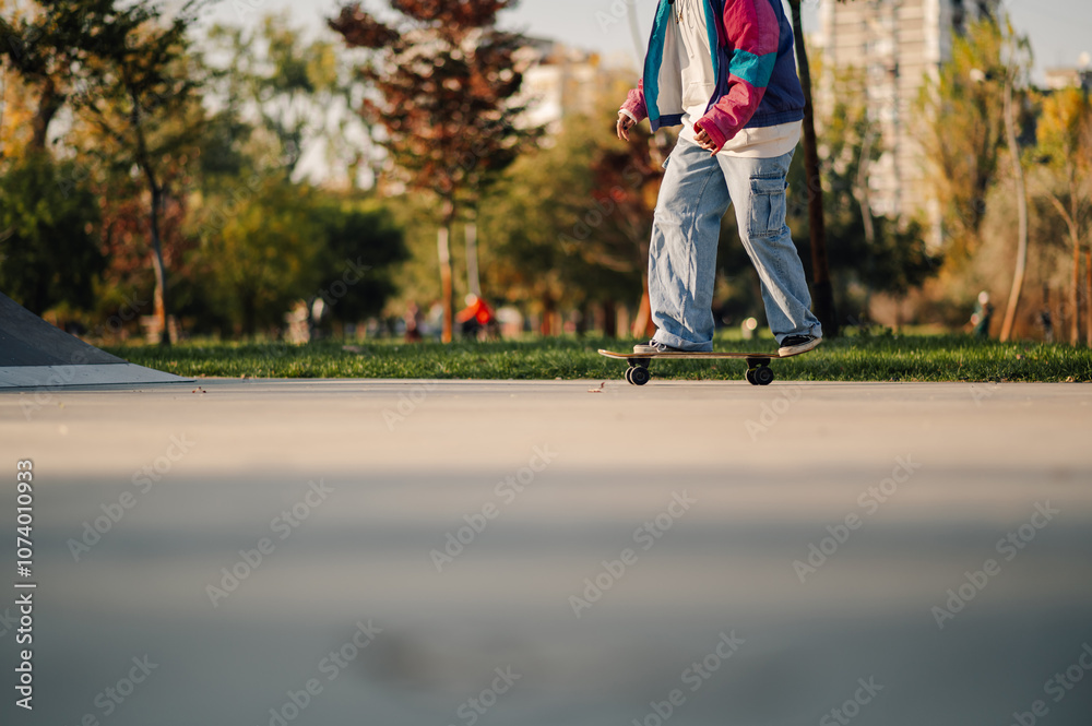 Skater riding skateboard in skatepark at sunset