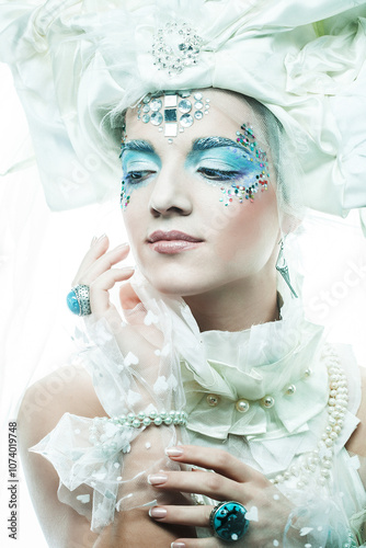 Winter Beauty Woman in clothes made of frozen flowers covered with frost, with snow on her face.