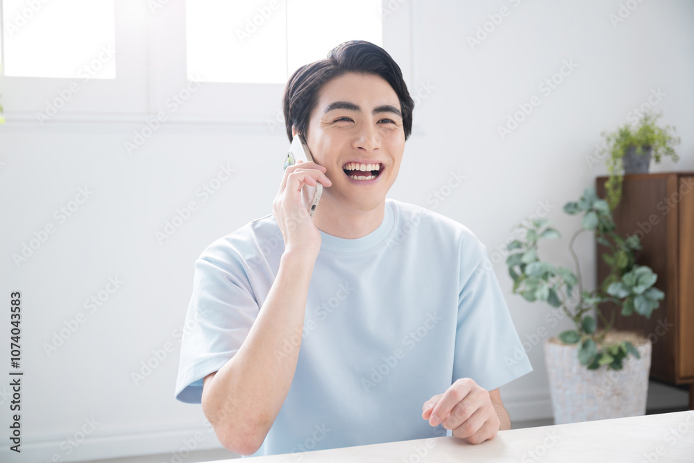 Handsome man looking up holding and talking on his phone in a beautiful living room. Handsome man looking up holding and talking on his phone in a beautiful living room.