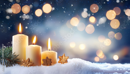 Christmas background with candles on a snow and bokeh