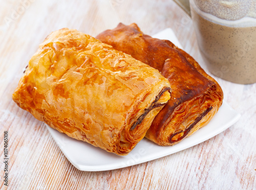 Crisp napolitana from puff pastry with meat and cheese filling served with cup of tea. Traditional Spanish pastries.. photo