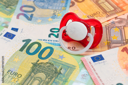 Childfree, Contraception and Birth Control Concept: Baby Pacifier on the Euro Banknotes. Having Children is Expensive and Unprofitable photo