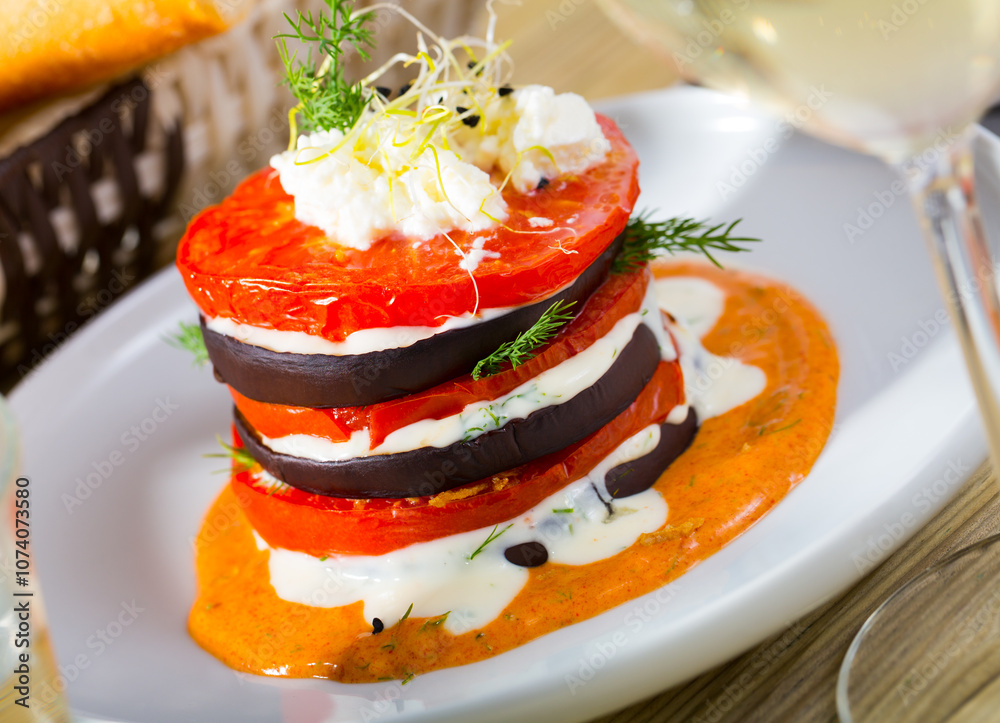 Image of tasty stack of fried eggplants and tomatoes on spicy sauce served at plate Image of tasty stack of fried eggplants and tomatoes on spicy sauce served at plate