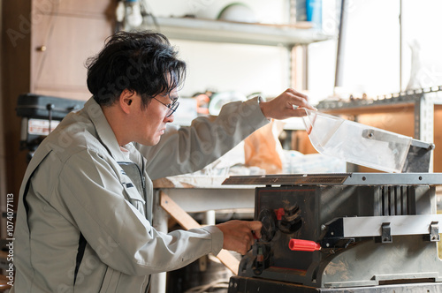 丸鋸・昇降盤を使う作業着姿の中年男性 