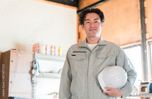 倉庫・作業場・工場にいる建築業・土木業の作業着姿の中年男性（一人親方・大工・職人）
