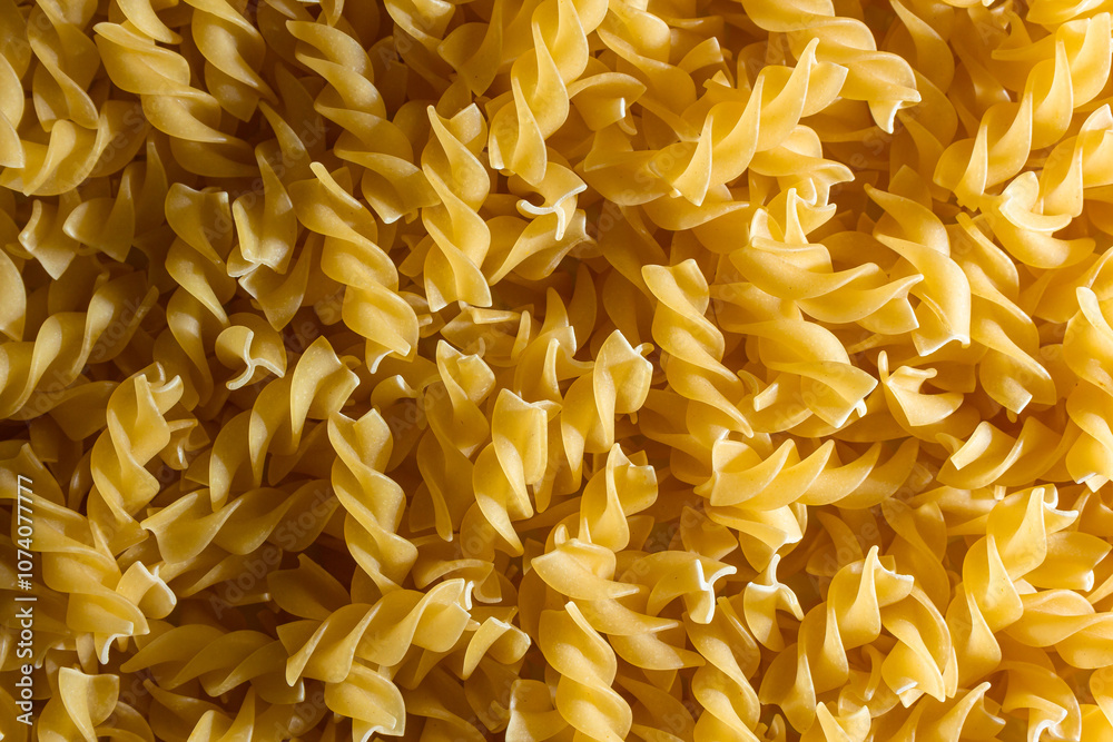 Uncooked Fusilli Pasta: A Culinary Canvas of Spiral Macaroni, Creating a Lively and Textured Background for Gourmet Cooking. Dry Pasta. Raw Macaroni - Top View, Flat Lay Uncooked Fusilli Pasta: A Culinary Canvas of Spiral Macaroni, Creating a Lively and Textured Background for Gourmet Cooking. Dry Pasta. Raw Macaroni - Top View, Flat Lay