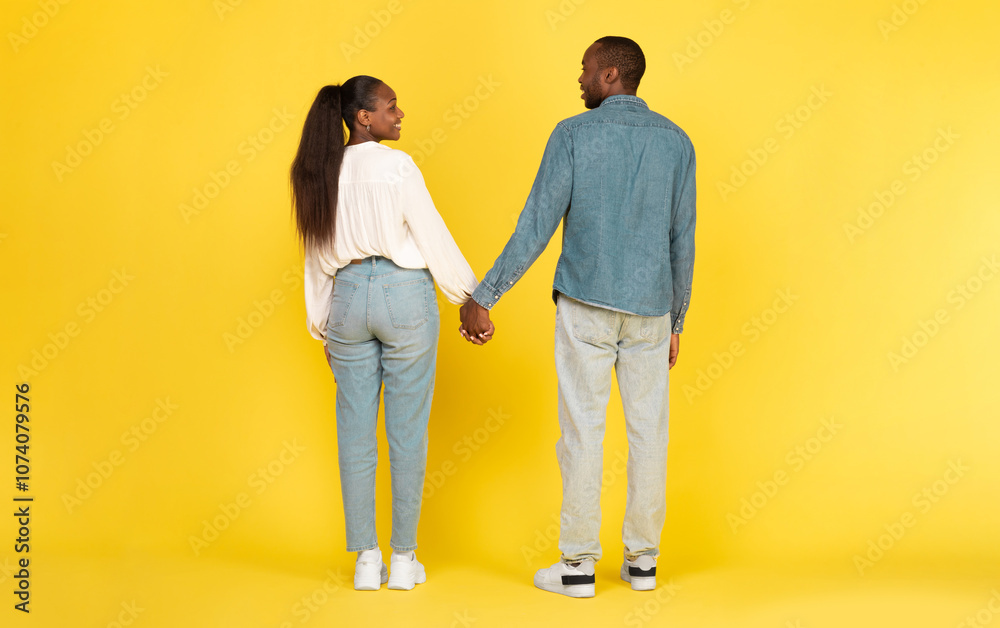 Black Couple Holding Hands Standing Back To Camera Posing Over Yellow Background. Studio Shot Of Unrecognizable African American Spouses. Marriage And Love Concept. Full Length Black Couple Holding Hands Standing Back To Camera Posing Over Yellow Background. Studio Shot Of Unrecognizable African American Spouses. Marriage And Love Concept. Full Length