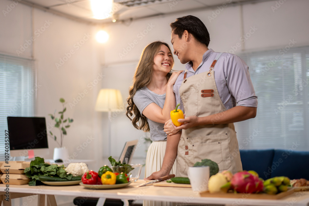 A man and woman are in a kitchen, holding a pepper and smiling at each other A man and woman are in a kitchen, holding a pepper and smiling at each other