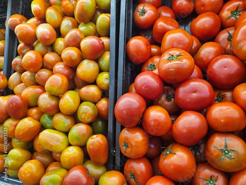 A vibrant stack of fresh red tomatoes displayed at a fruit market, showcasing their natural color and plump texture. Perfect for themes of fresh produce and healthy eating