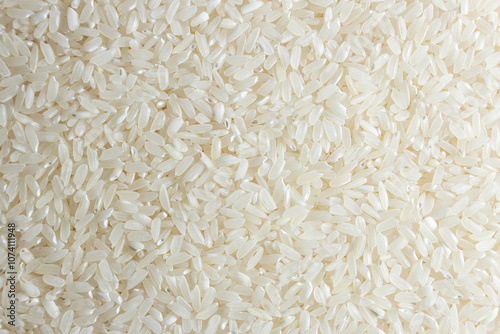 Dry Uncooked White Rice Background - Top View, Flat Lay. Scattered Raw Long Grain Rice. Asian Cuisine and Culture. Healthy Eating Ingredients. Diet Food