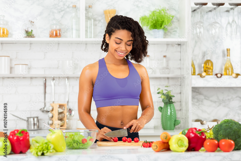 Cooking At Home. Beautiful young african woman preparing vegetable salad in modern kitchen, cutting tomatoes, copyspace Cooking At Home. Beautiful young african woman preparing vegetable salad in modern kitchen, cutting tomatoes, copyspace