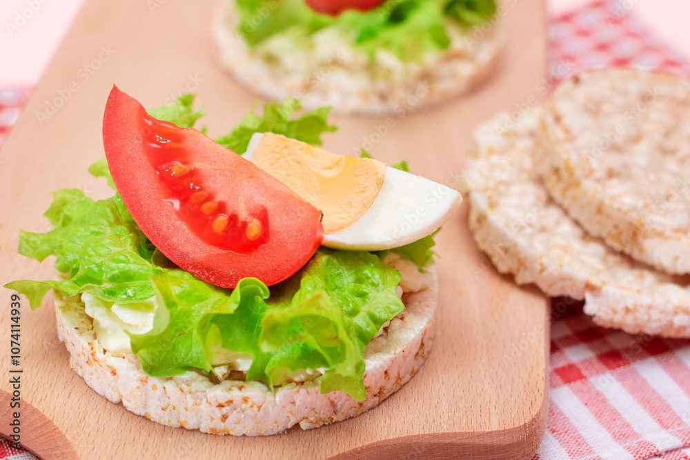 Rice Cake Sandwiches with Tomato, Lettuce and Egg on Wooden Cutting Board. Easy Breakfast. Diet Food. Quick and Healthy Sandwiches. Crispbread with Tasty Filling. Healthy Dietary Snack Rice Cake Sandwiches with Tomato, Lettuce and Egg on Wooden Cutting Board. Easy Breakfast. Diet Food. Quick and Healthy Sandwiches. Crispbread with Tasty Filling. Healthy Dietary Snack