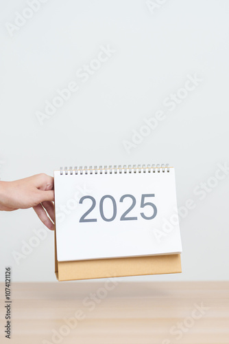 Business woman hand change 2025 Year Calendar on table in office background. countdown, Happy New Year, Resolution, Year End and New Start and Goals Plan Action Concept