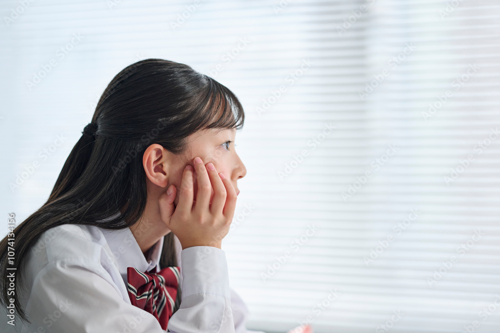 教室で考え事をする女子中学生