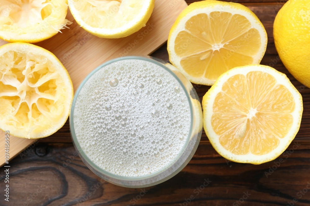 Fresh juice in glass and lemons on wooden table, top view Fresh juice in glass and lemons on wooden table, top view