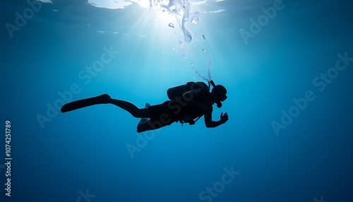 Silhouette of a diver swimming underwater. photo