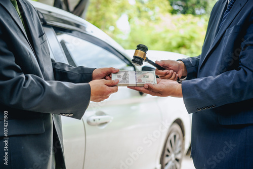 Asian clients engage with a car insurance agent beside a wrecked vehicle. They examine the policy details, assess the damage, and finalize paperwork related to the insurance claim and repairs.