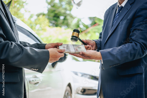 Asian clients engage with a car insurance agent beside a wrecked vehicle. They examine the policy details, assess the damage, and finalize paperwork related to the insurance claim and repairs.