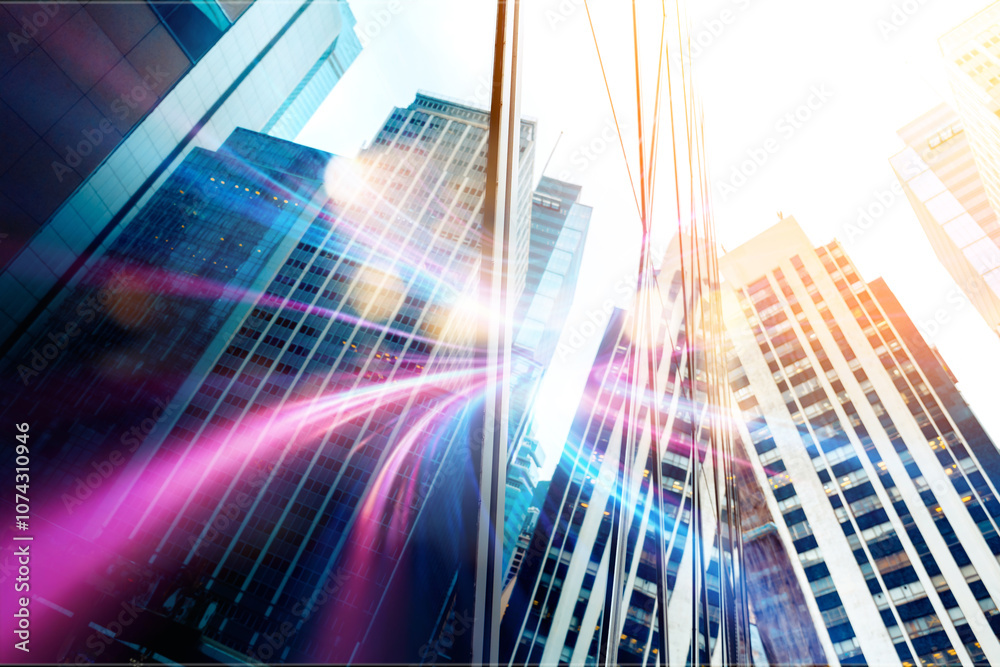A low angle view of a city street with tall buildings and colorful streaks of light. A low angle view of a city street with tall buildings and colorful streaks of light.