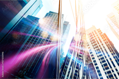 A low angle view of a city street with tall buildings and colorful streaks of light.