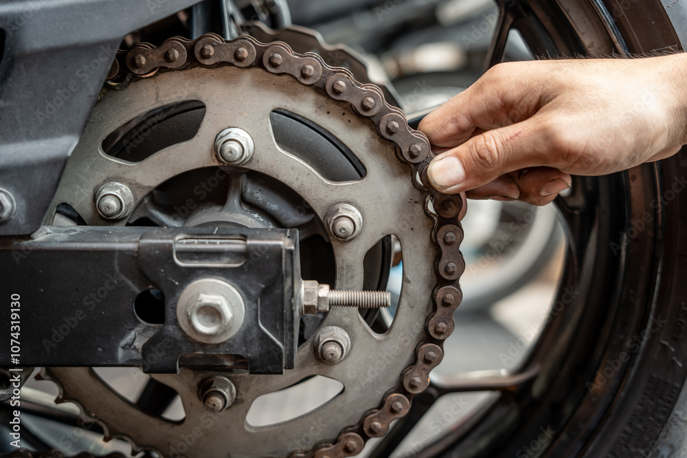 Mechanic Check chain's wear level by attempting to pull it away from the back of the rear sprocket in garage,Maintenance and repair motorcycle concept