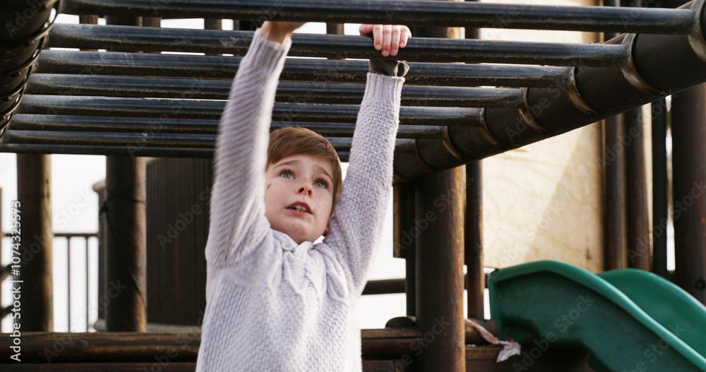 Fototapeta premium Boy, child and outdoor on monkey bars at playground, swing or adventure with lifting, learning and balance. Kid, memory and exercise on jungle gym at park for challenge, climbing or sunshine in Spain