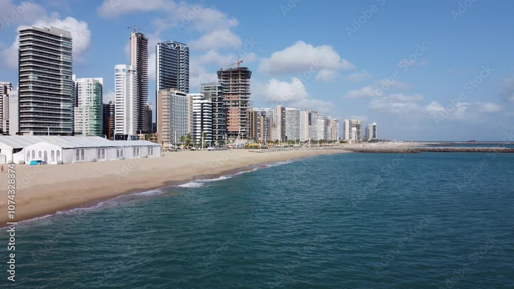 beautiful low-angle shot of forward movement with drone on the seafront of Fortaleza, calm sea, calm waves, green water