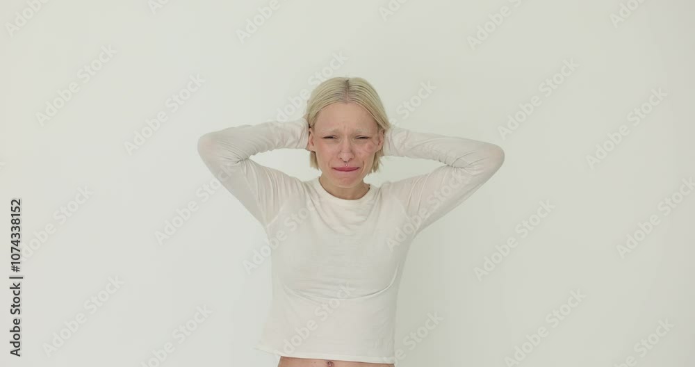 Young woman with blond hair reacts with disappointment in stress on a white background Young woman with blond hair reacts with disappointment in stress on a white background